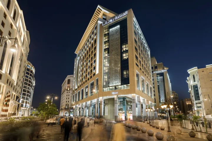 Façade de l'Al Manakha Rotana à Médine, de nuit, sur l'esplanade piétonne